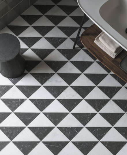Fitz Black and white Honed Marble Triangle tiled floor with small black stool and white freestanding basin in corner