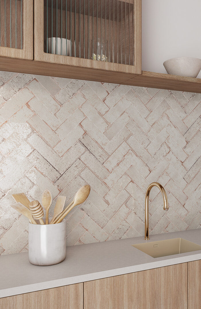 Off white porcelain wall tiles in a herringbone layout.