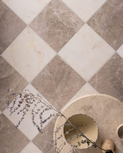 Calacatta Amber and Porcini marble tiles laid in a diamond checkerboard pattern, showcasing warm white and taupe tones with natural veining.
