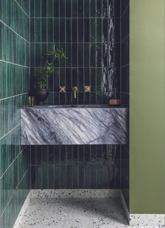 Bottle green Hoxton Zellige-style tiles on a bathroom wall.